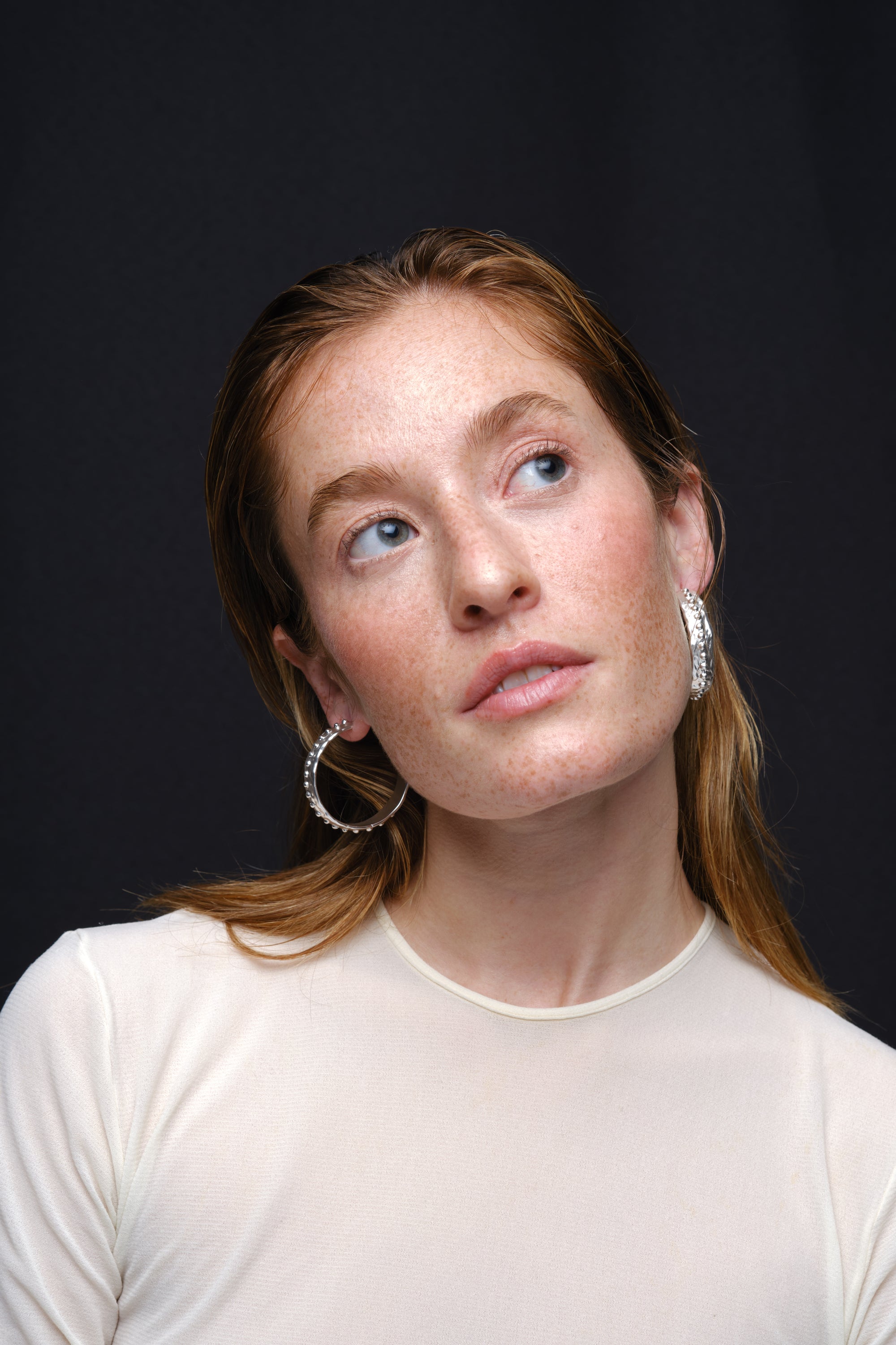 Silver textured hoop earrings worn on model portrait