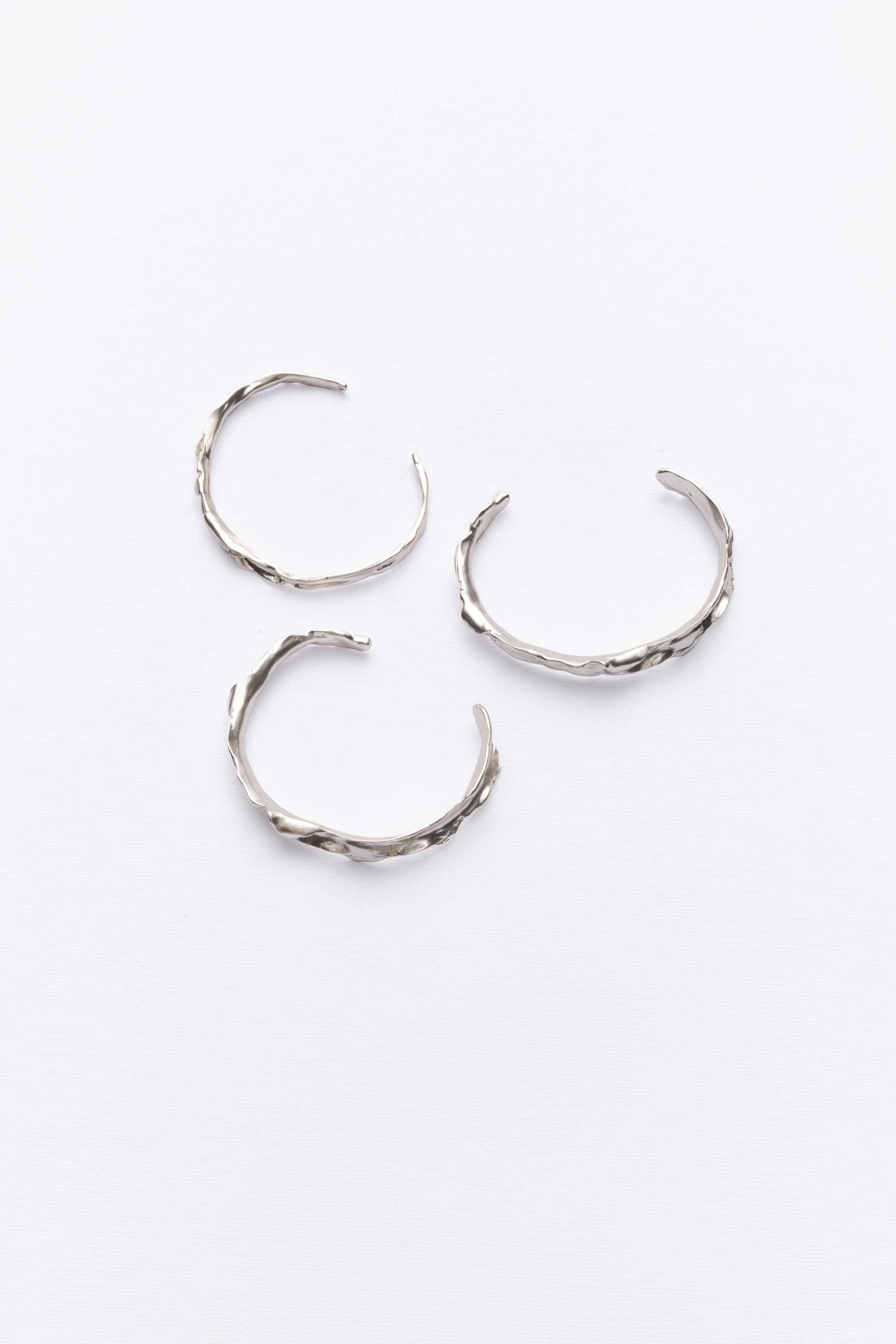 Silver textured organic cuff bracelets flat lay