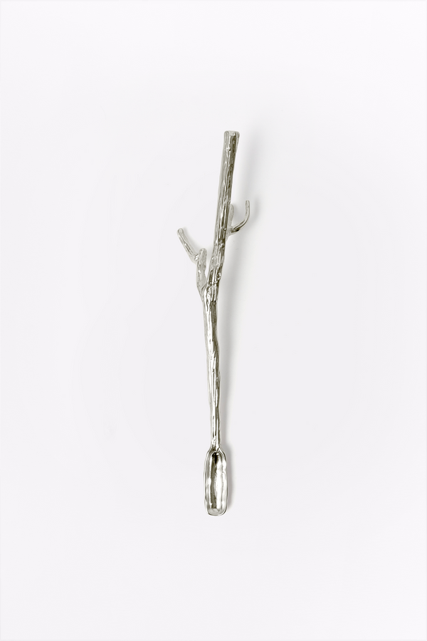 Silver branch-shaped spoon on a white background