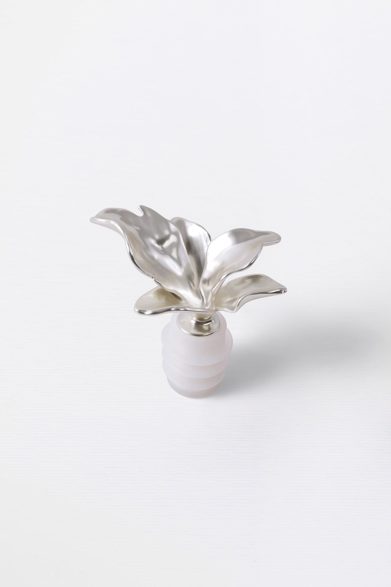 A silver metal wine cork in the shape of a bloom flower with a rubber seal.