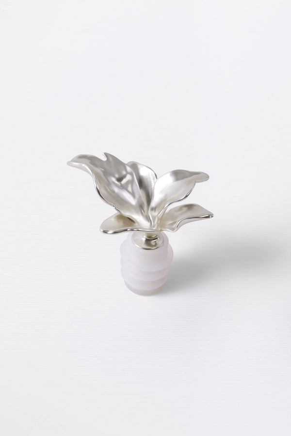 A silver metal wine cork in the shape of a bloom flower with a rubber seal.