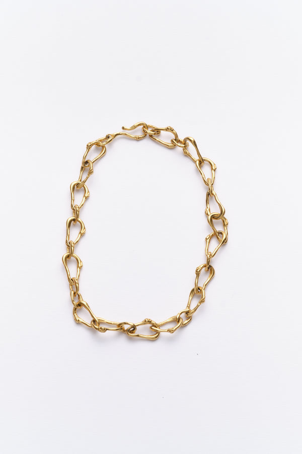 A gold-colored chain necklace with a unique link design, displayed against a white background.