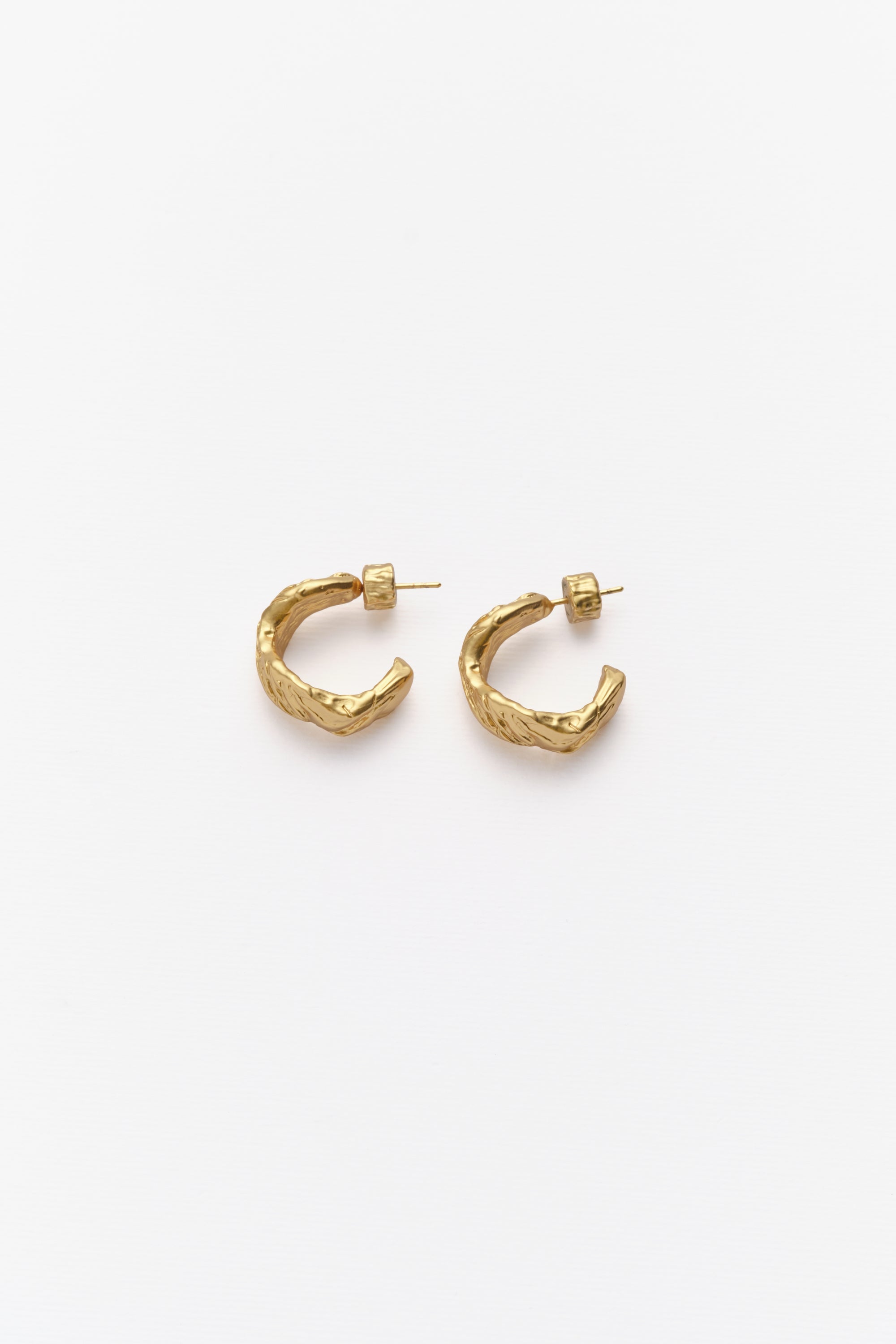 A pair of gold-colored hoop earrings against a white background