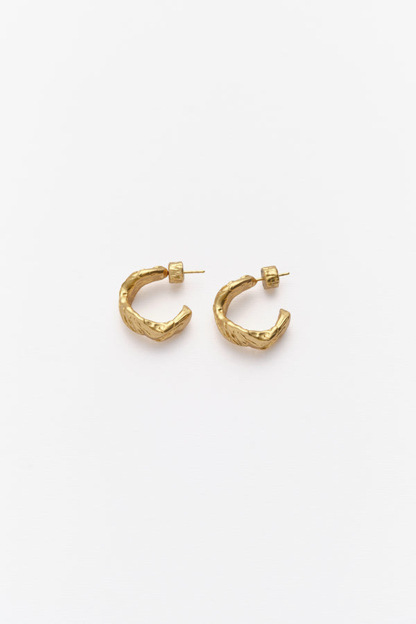 A pair of gold-colored hoop earrings against a white background