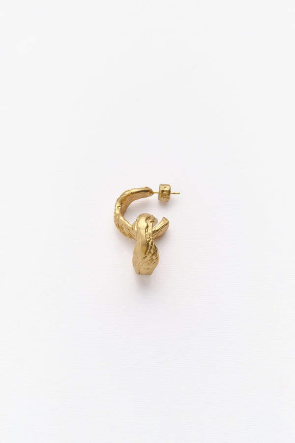 A single gold-colored hoop earring with an irregular texture, displayed against a white background.