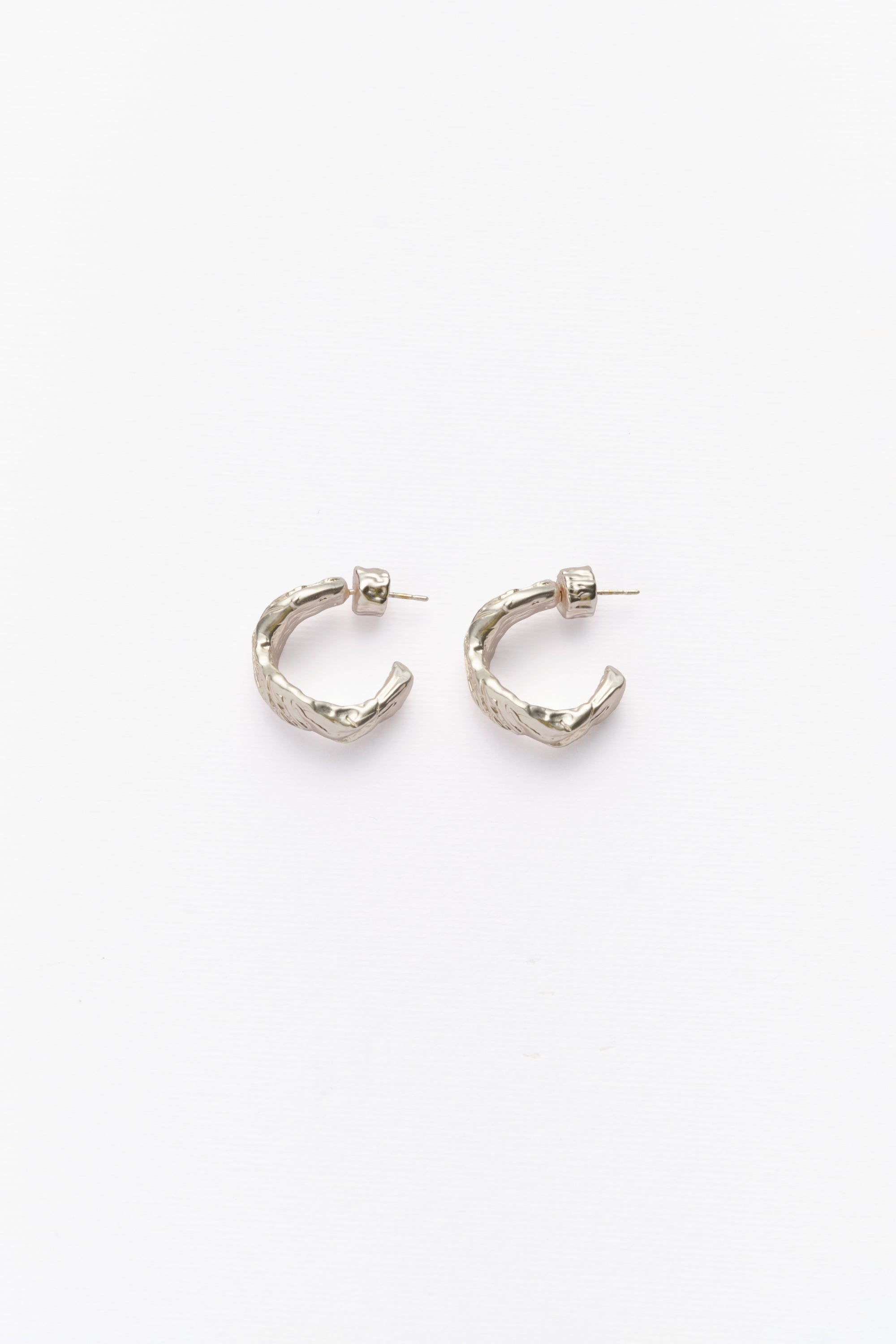 A pair of silver hoop earrings with textured surfaces, displayed against a white background