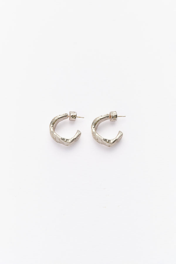 A pair of silver hoop earrings with textured surfaces, displayed against a white background