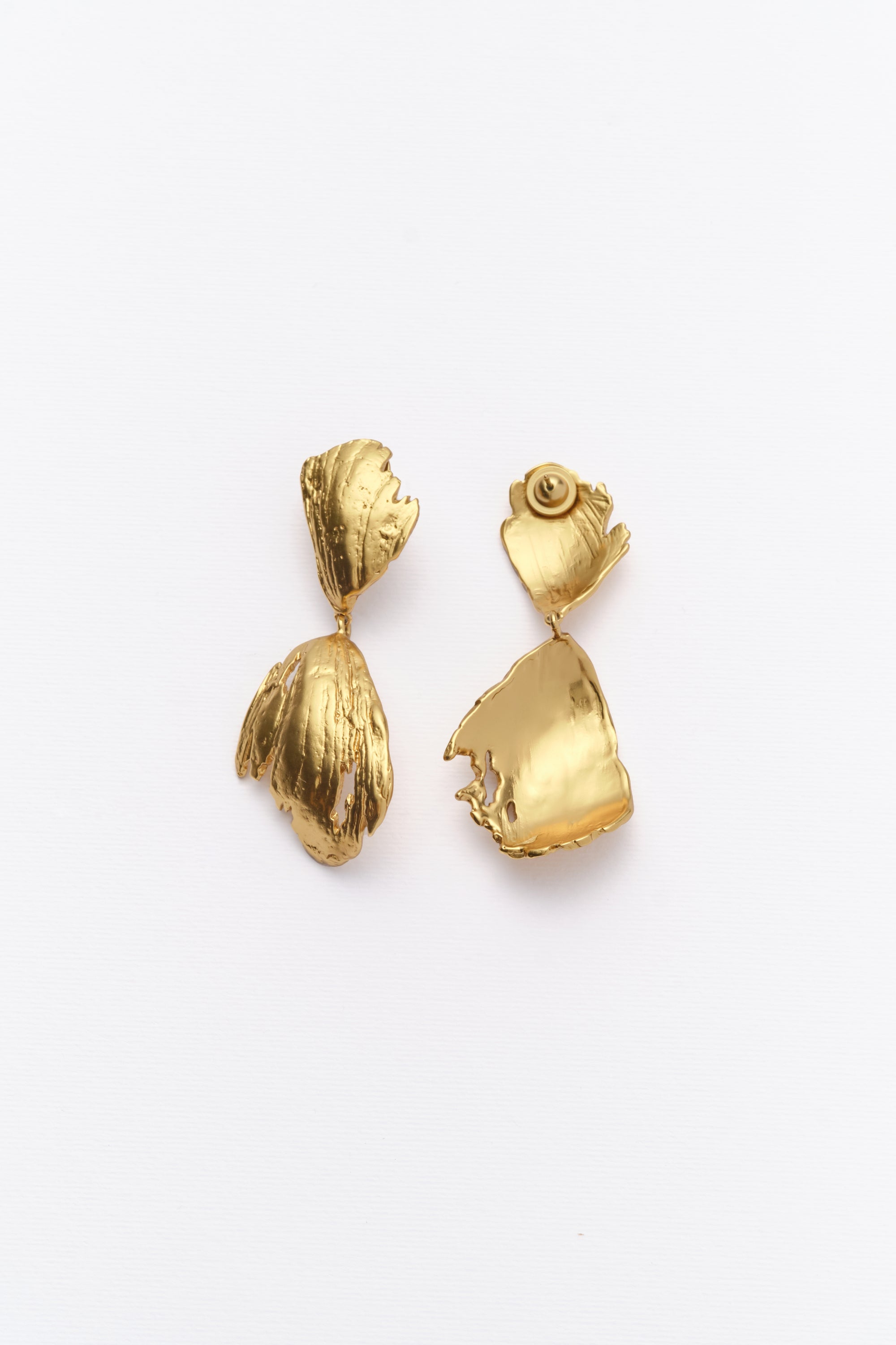 Sculptural textured gold drop earrings with organic shape on clean white background