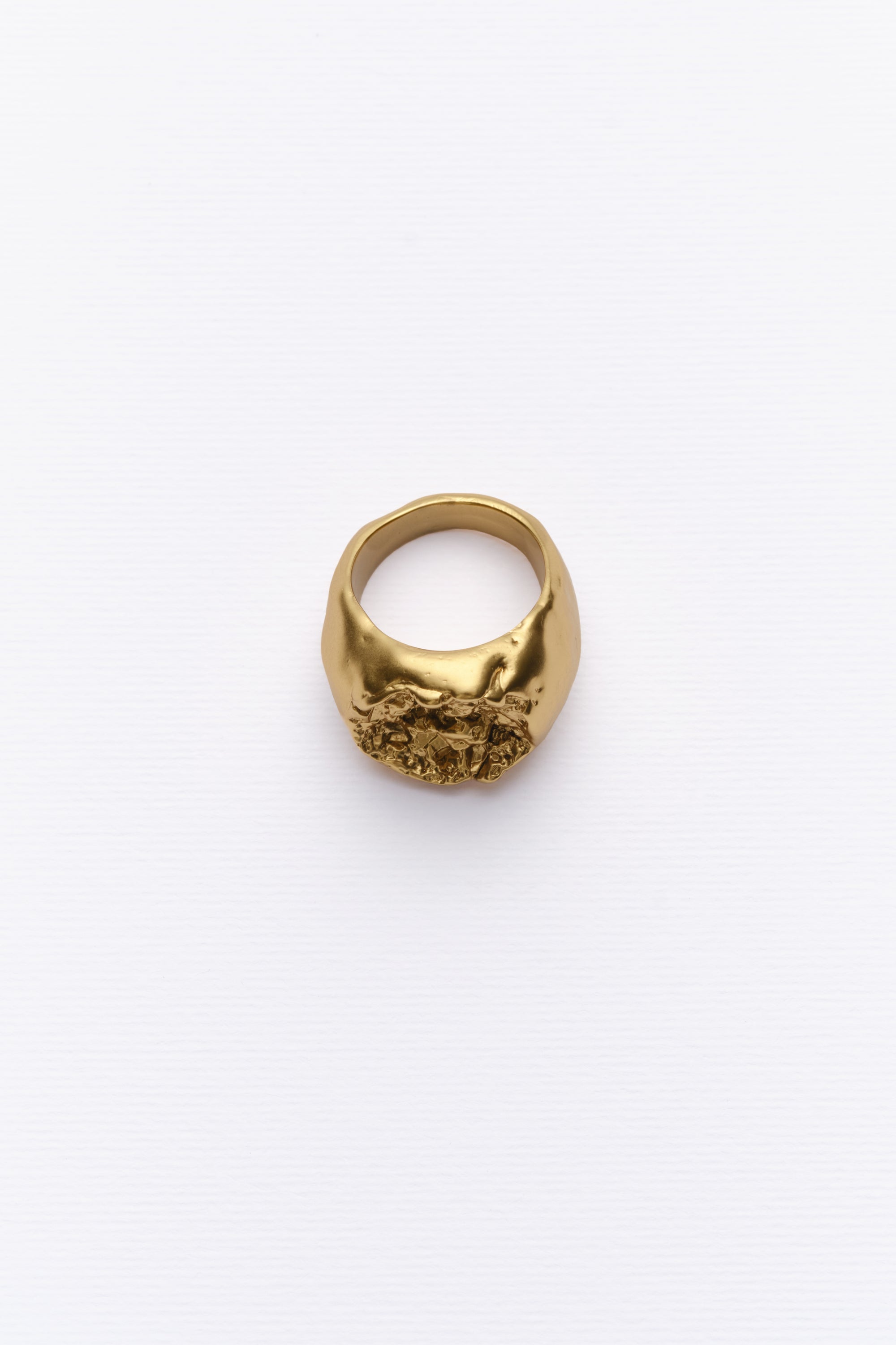 Bold textured gold statement ring with organic design on clean white background