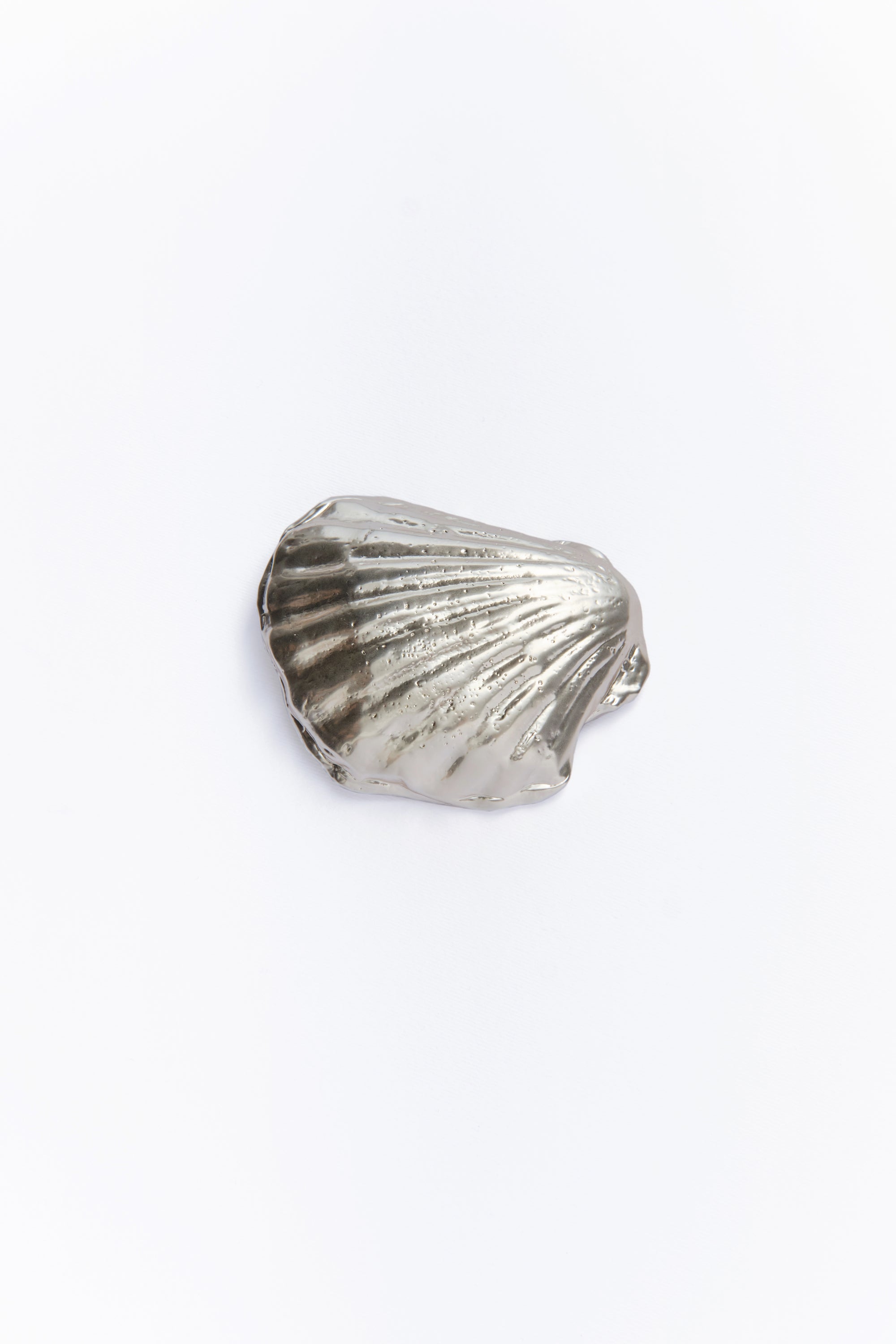 A silver incense holder designed to resemble a seashell.