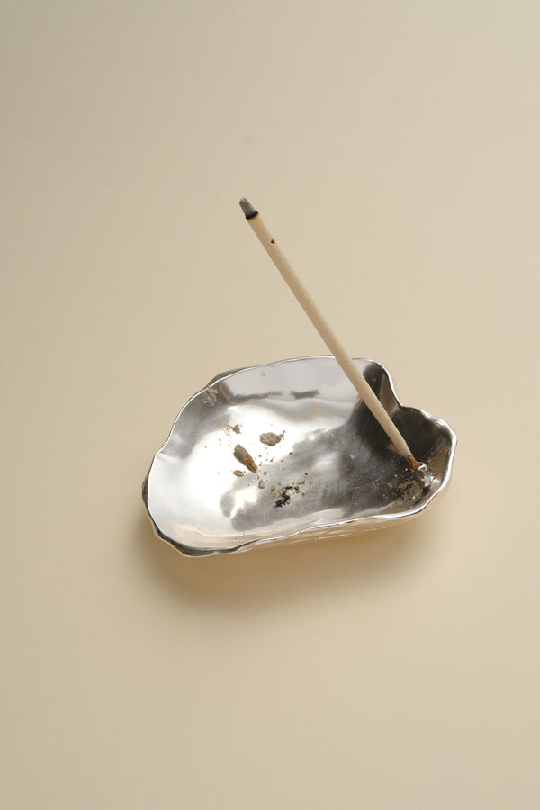 Silver sculptural incense holder with incense stick