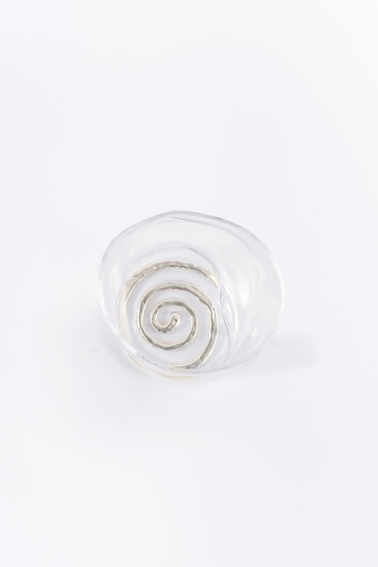 Clear glass knob with spiral coaster on a white background