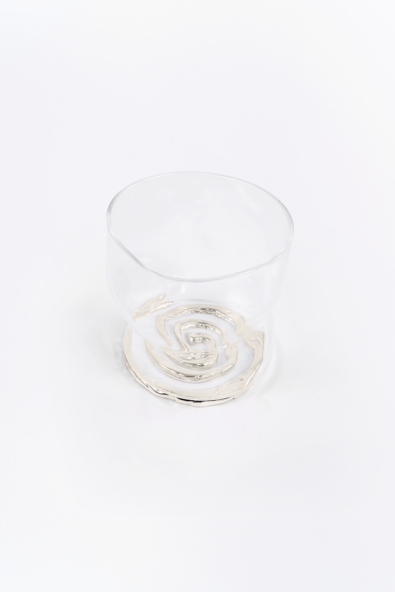 Clear glass rcup withe the spiral coaster on a white background