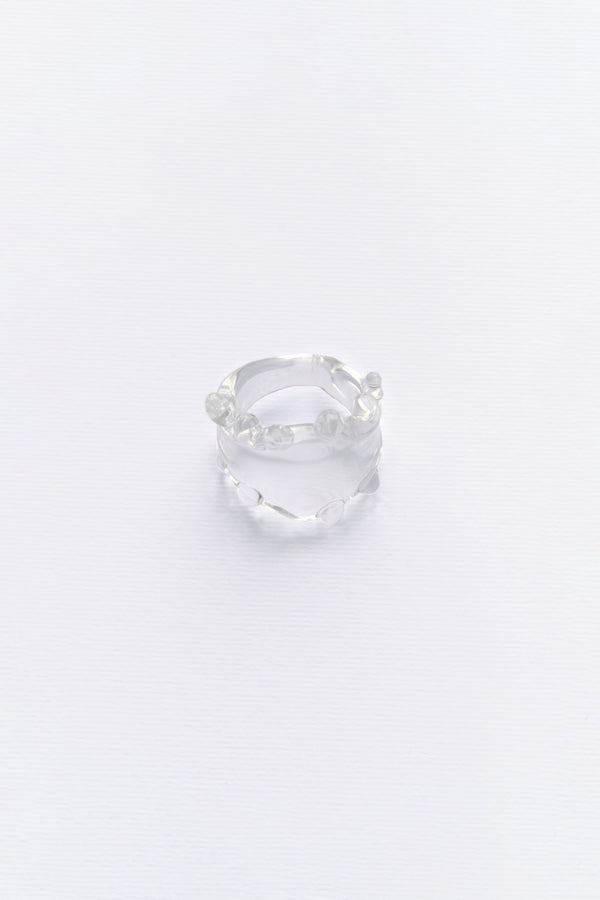 A clear glass ring with a smooth, sleek design, displayed against a white background.