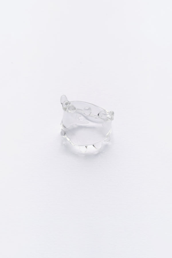 A clear glass ring with a smooth, sleek design, displayed against a white background.