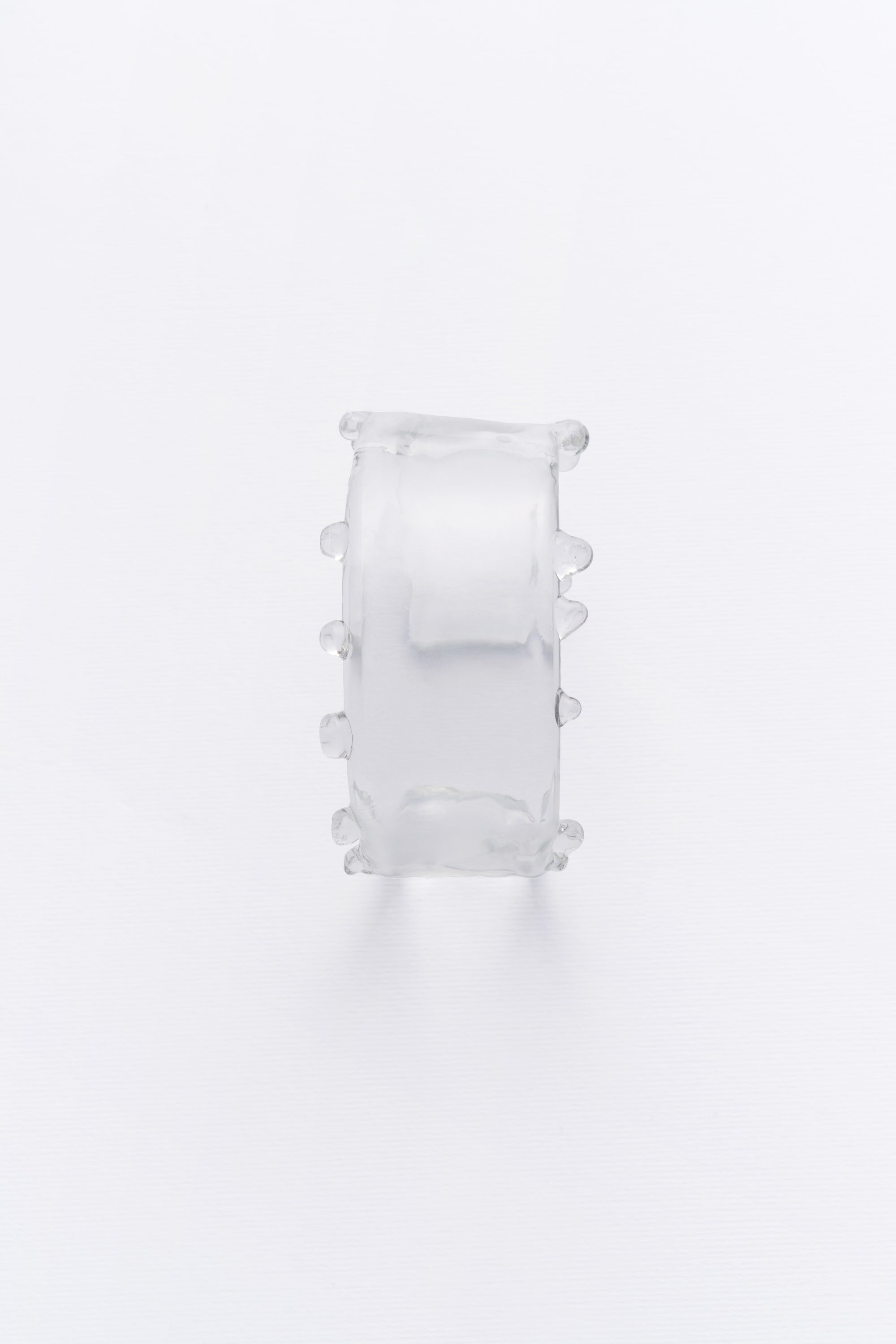 A clear crystal cuff bracelet with a smooth, elegant design, capturing the gentle flow of water.