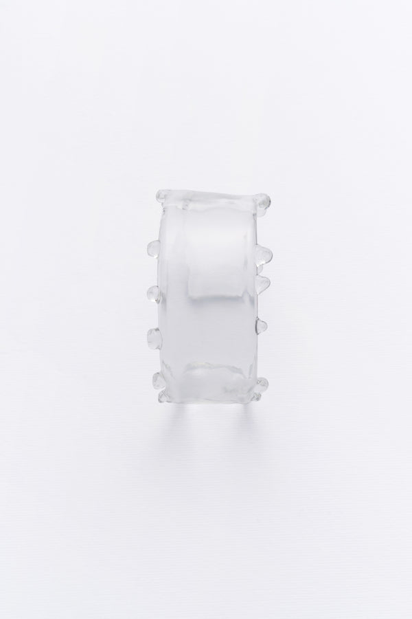 A clear crystal cuff bracelet with a smooth, elegant design, capturing the gentle flow of water.