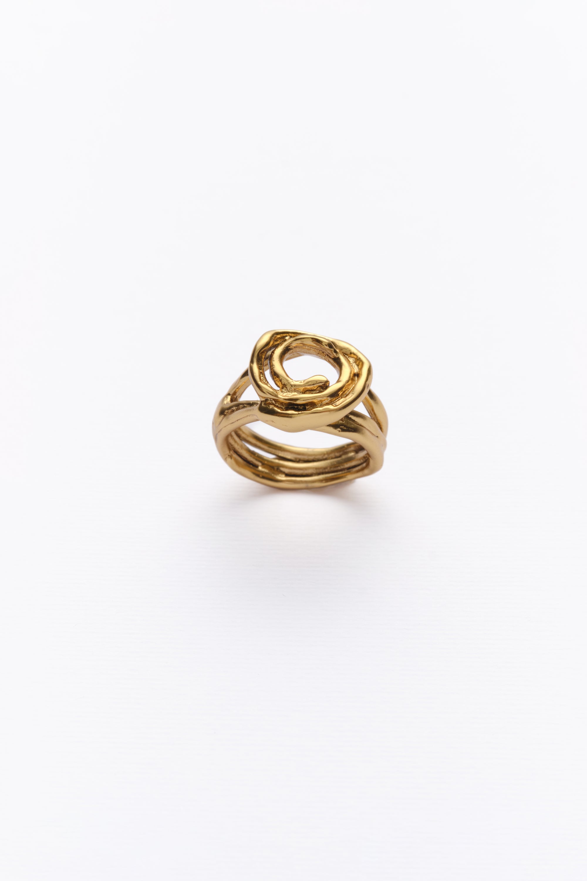 A gold ring with a unique design, featuring multiple bands twisted together, displayed against a white background.