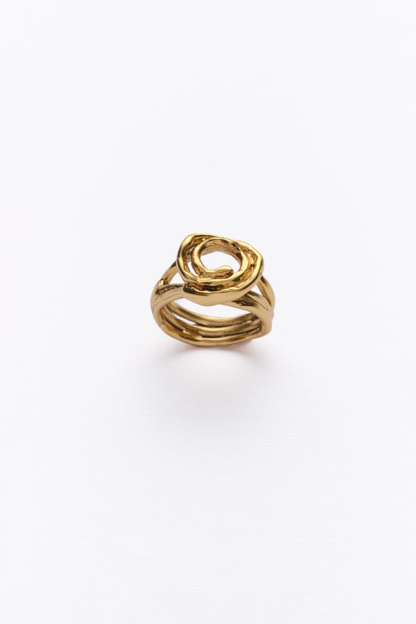 A gold ring with a unique design, featuring multiple bands twisted together, displayed against a white background.