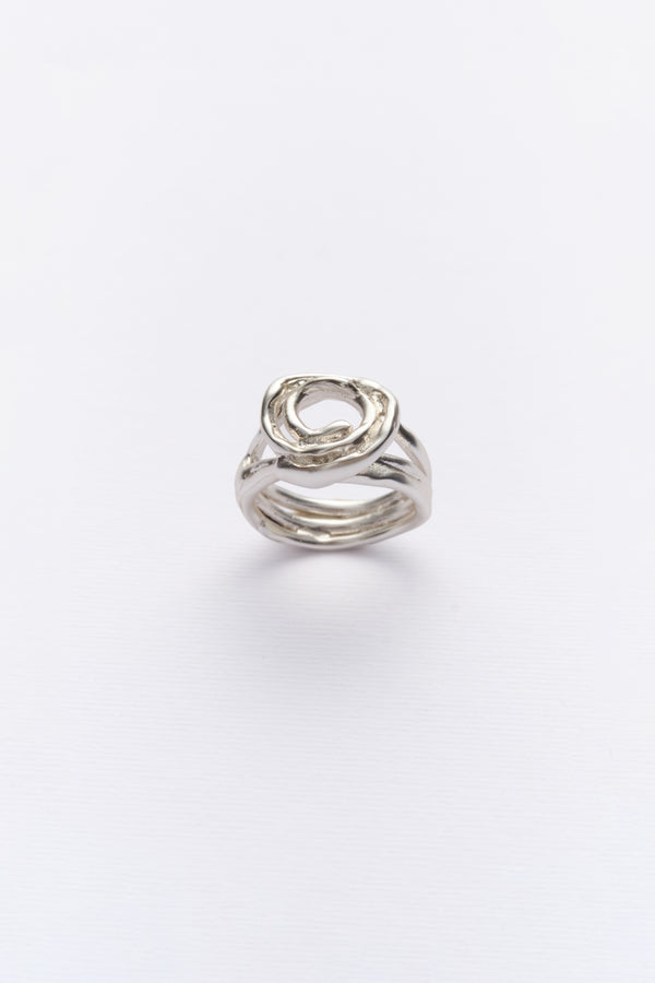A silver ring with a unique design, featuring multiple bands twisted together, displayed against a white background.