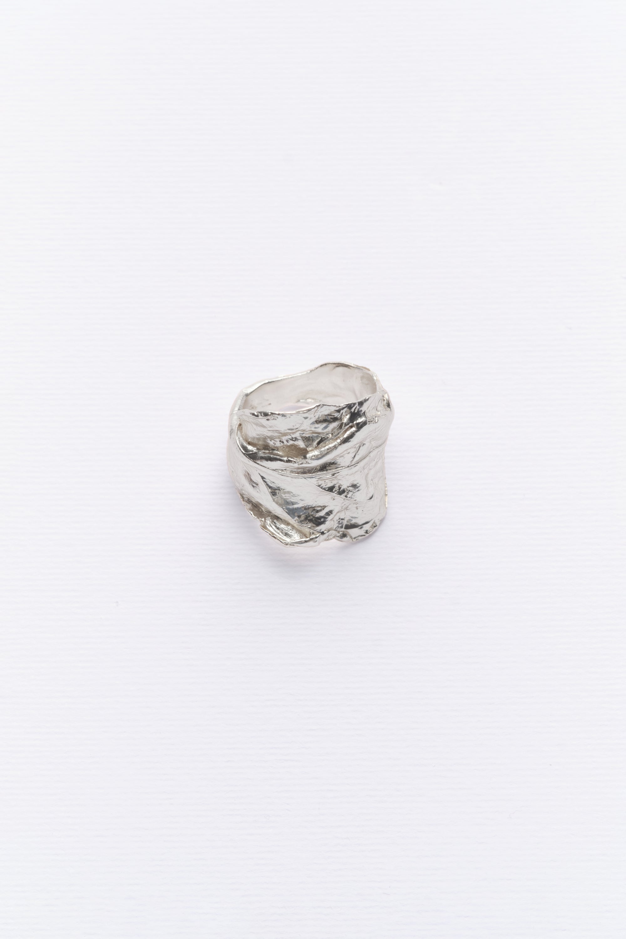 A silver ring with a natural leaft texture, displayed against a white background.