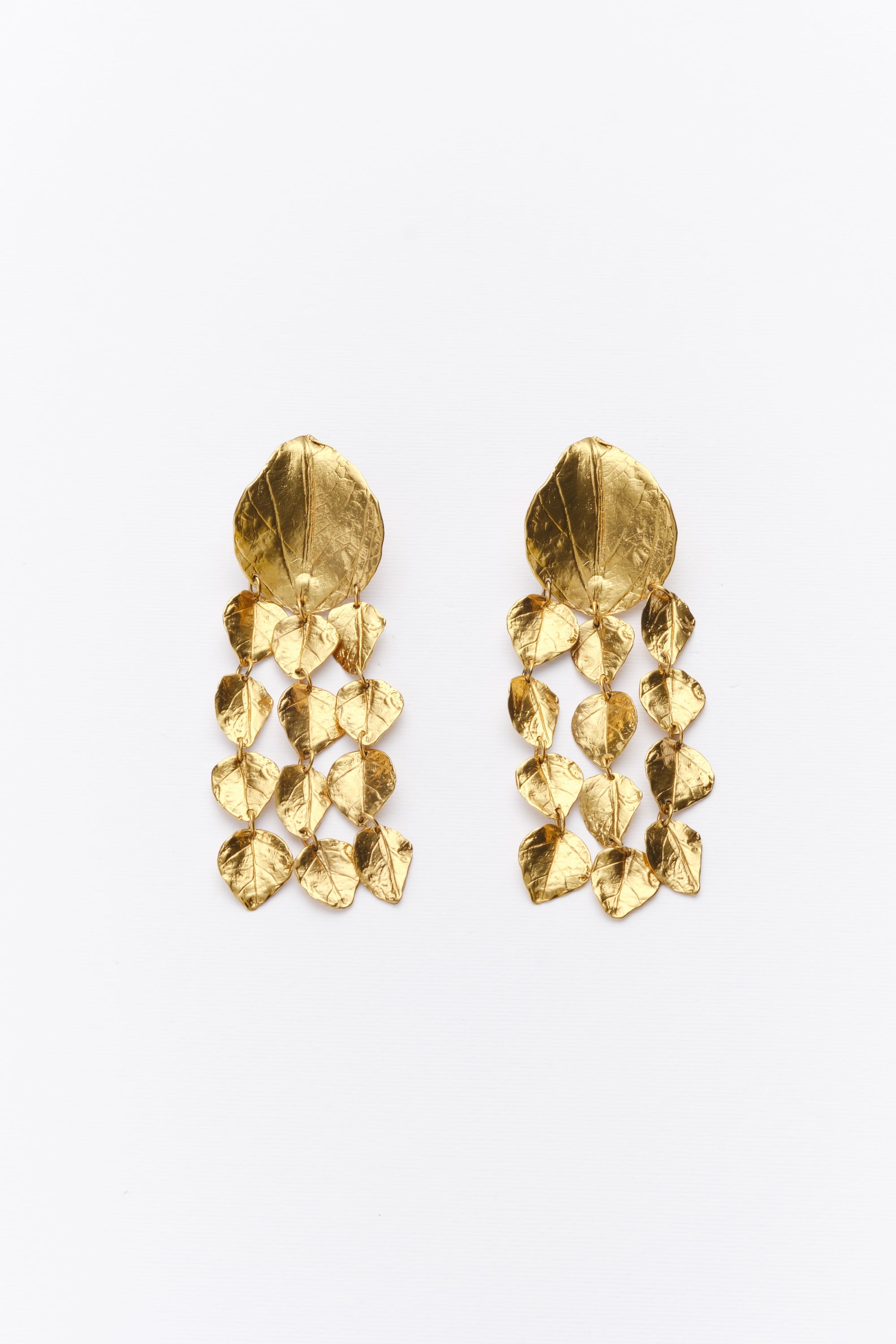 Gold textured leaf chandelier earrings flat lay
