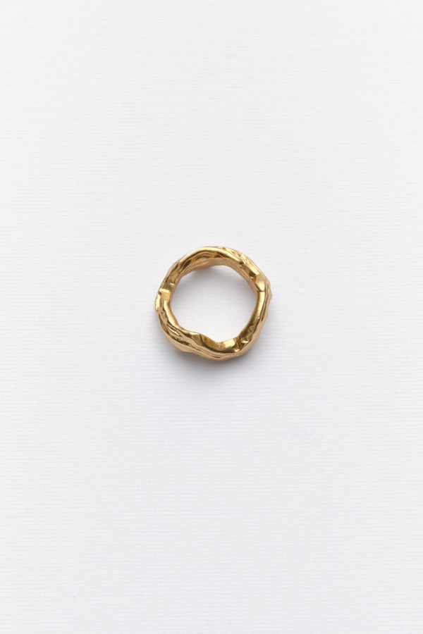 Minimalist textured gold ring displayed on clean white background