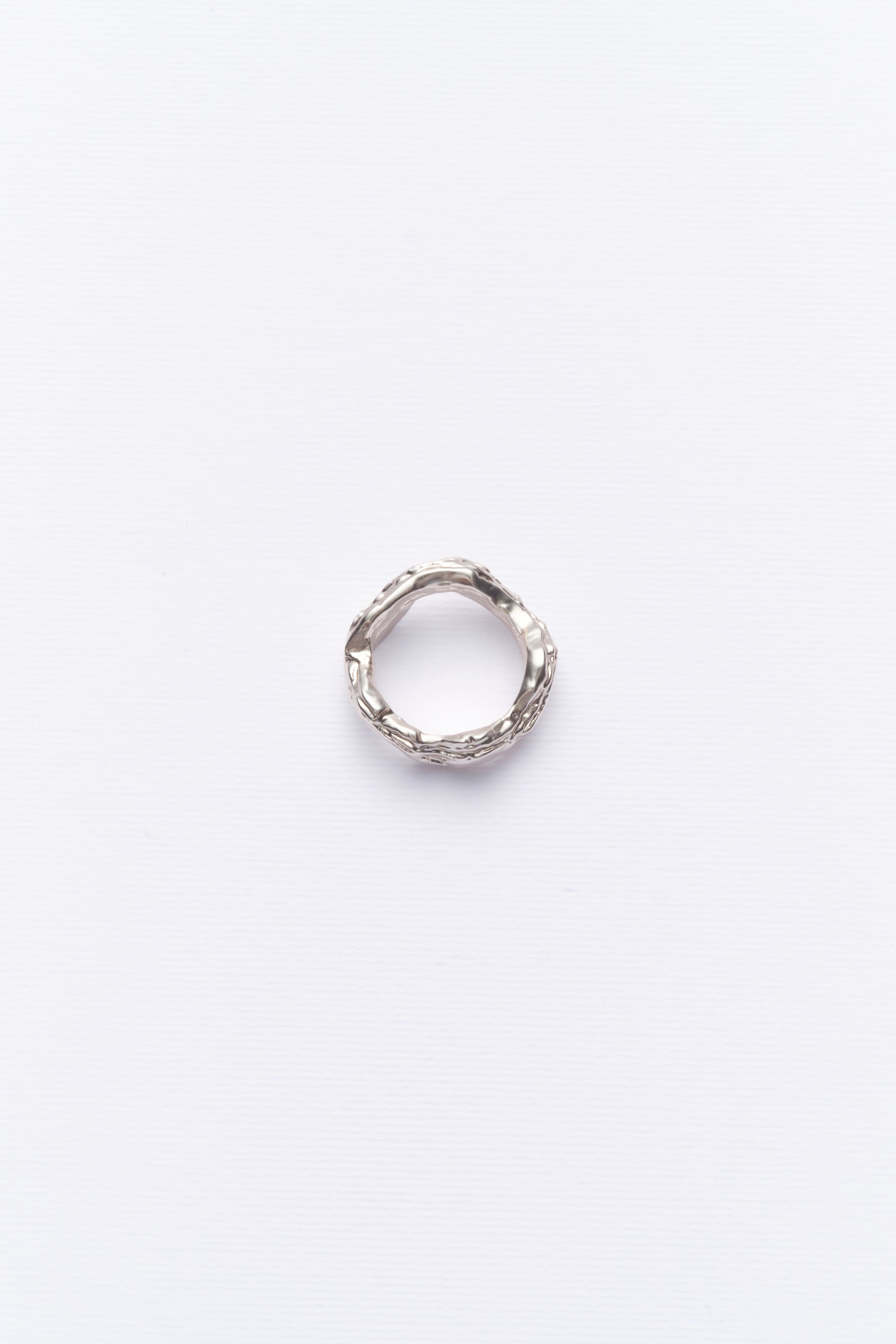 Minimalist textured silver ring displayed on clean white background