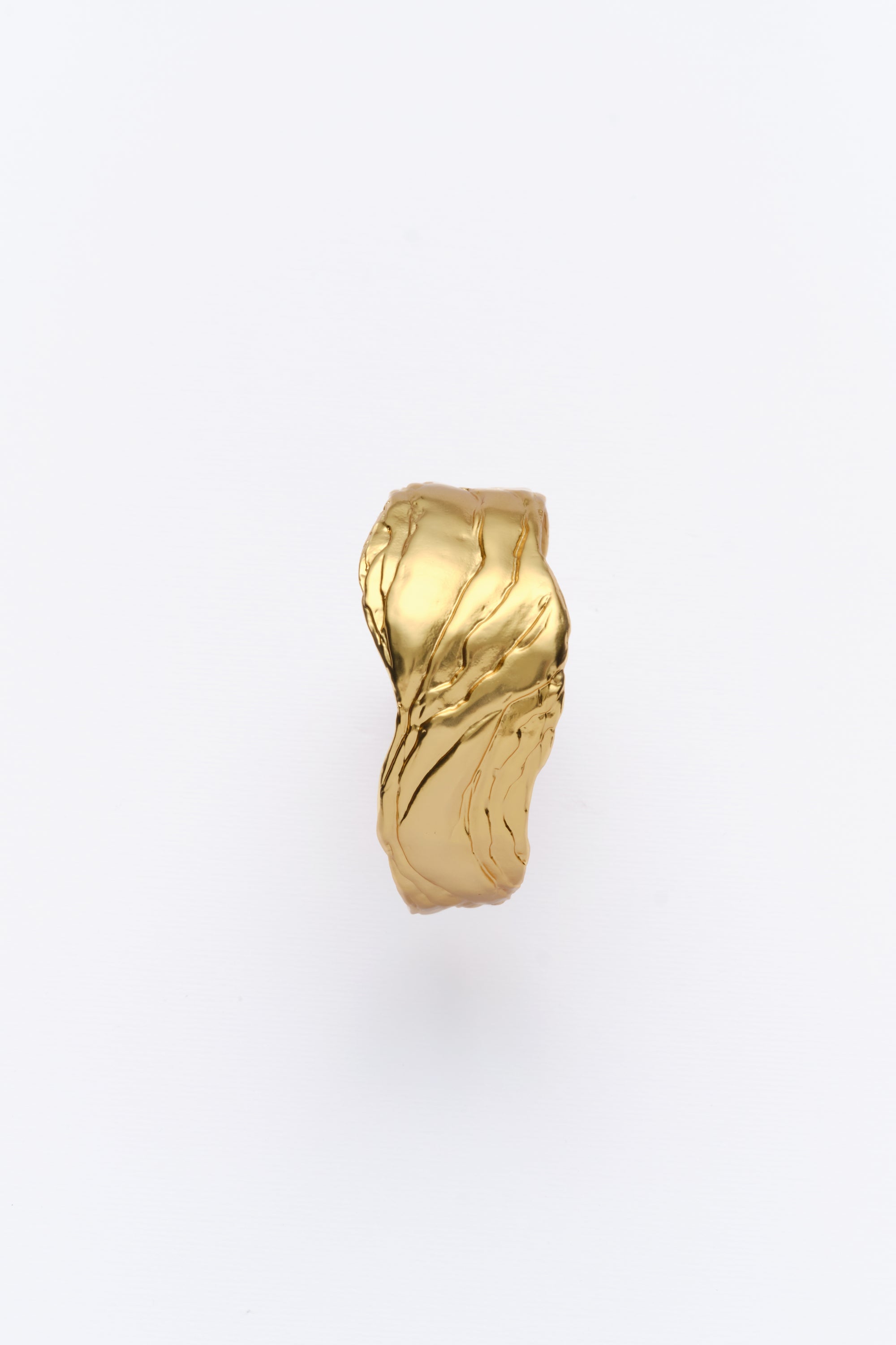 A gold-colored statement cuff bracelet with textured surfaces, displayed against a white background.