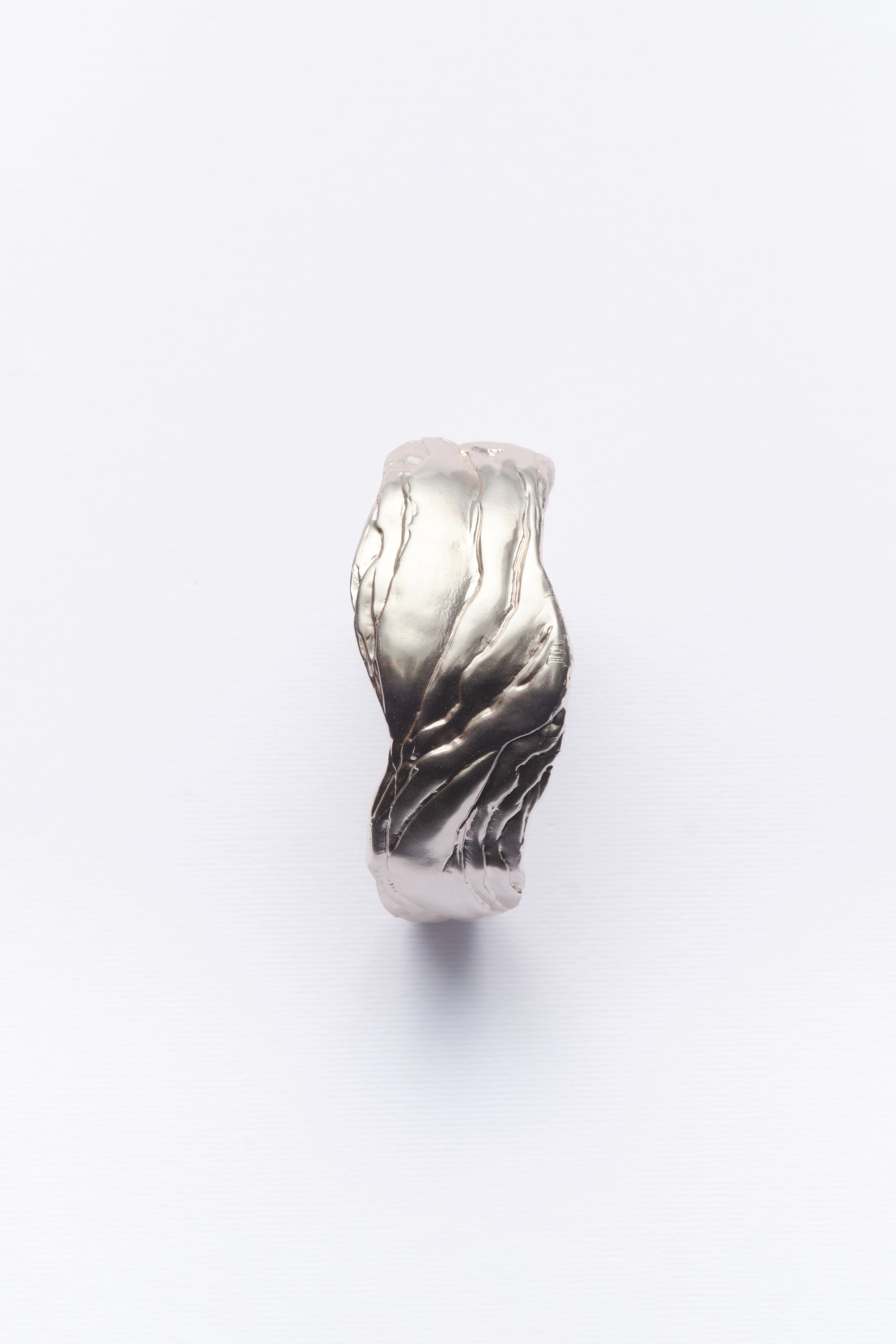 A silver statement cuff bracelet with textured design, displayed against a white background