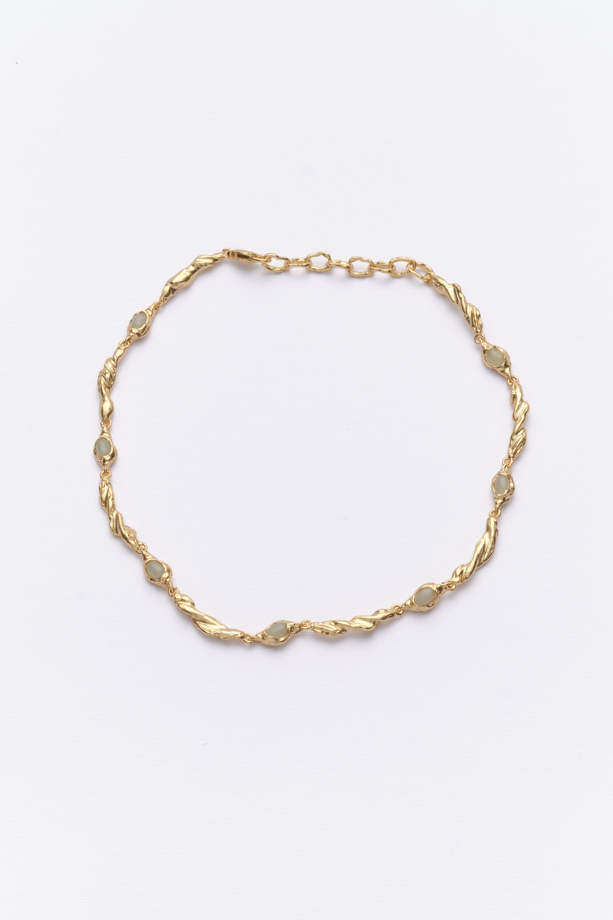 Gold organic link necklace with oval white gemstones flat lay
