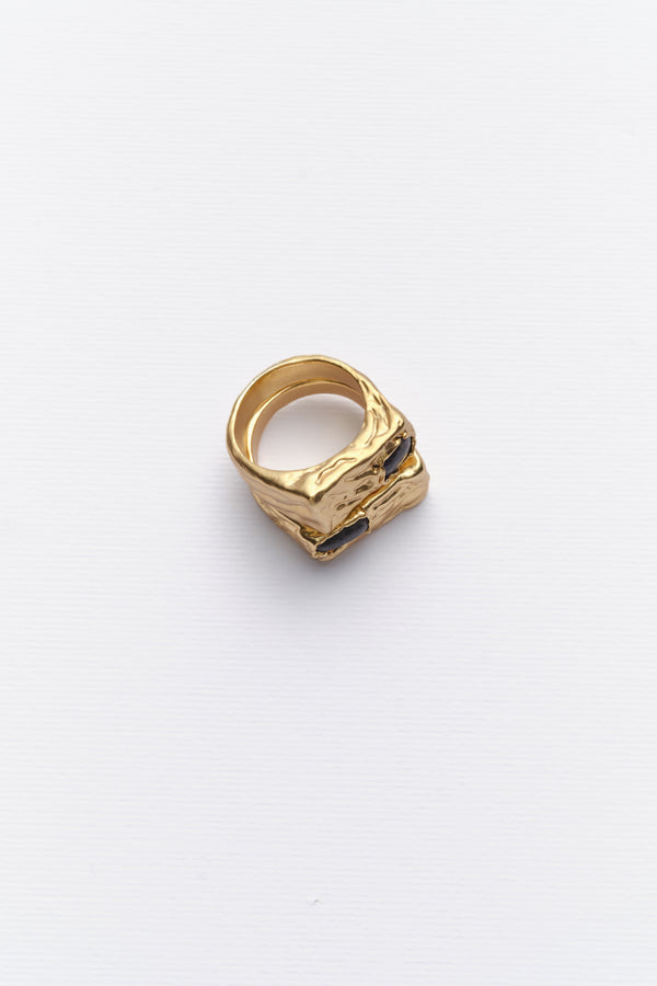 Gold sculptural signet ring with dark stone angled view