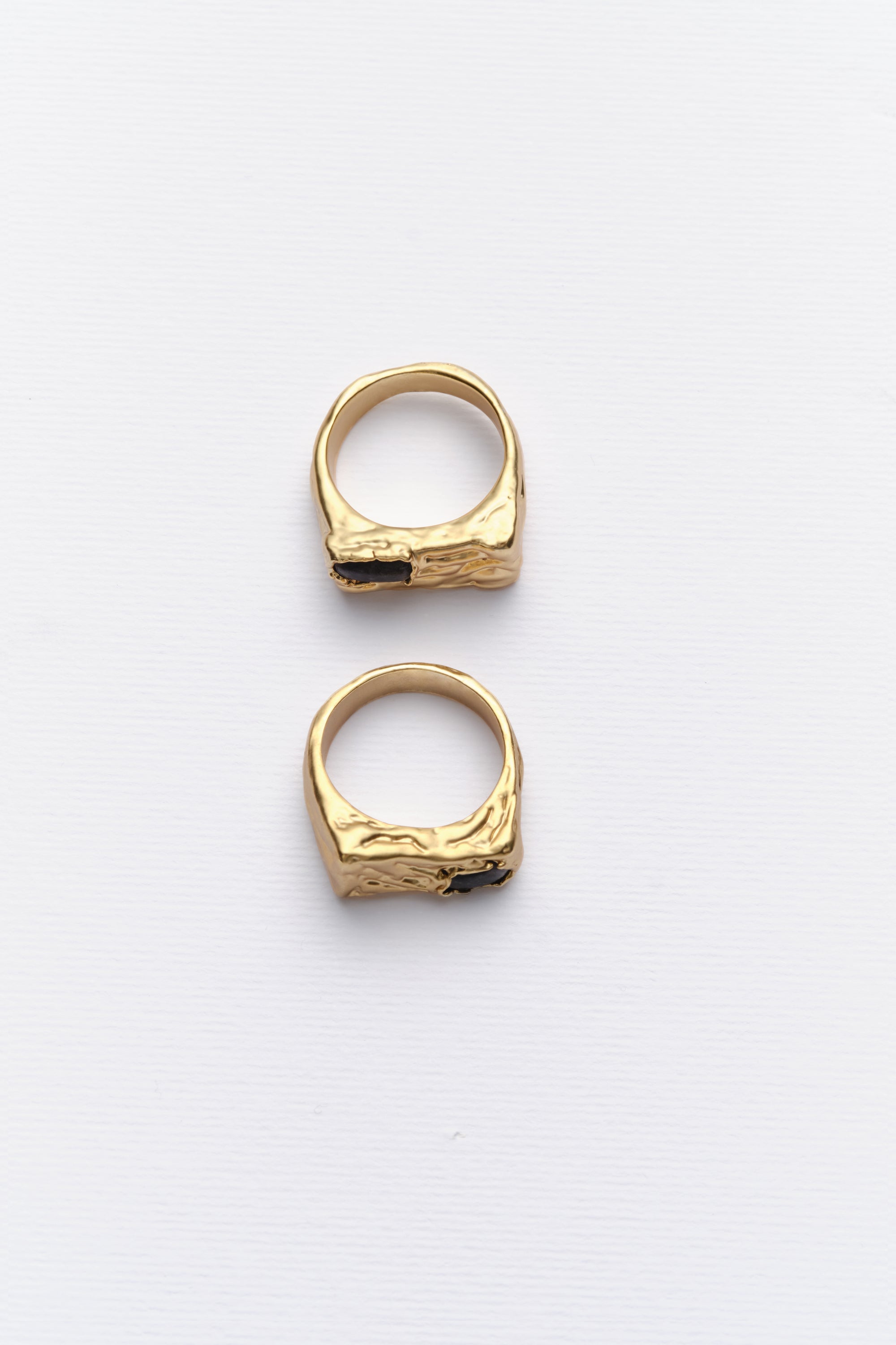 Pair of gold textured signet rings flat lay