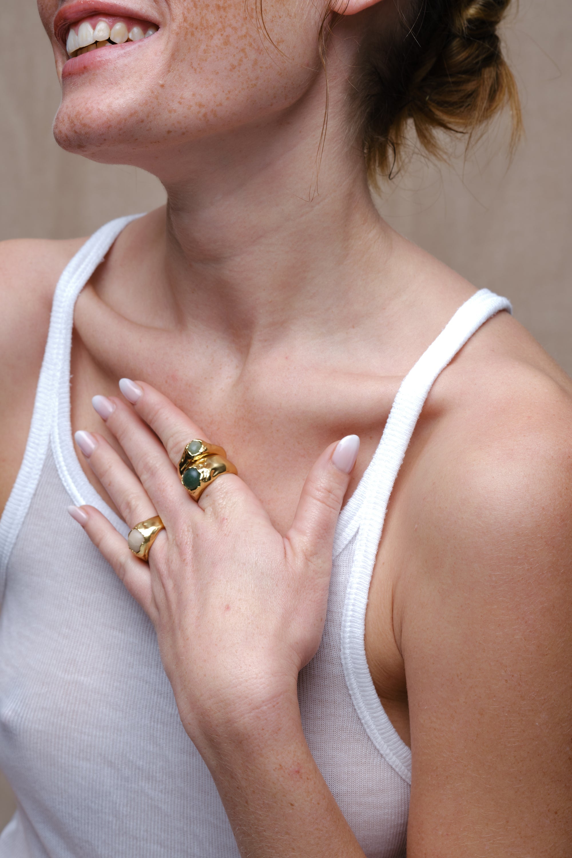 Stacked gold gemstone rings worn on model