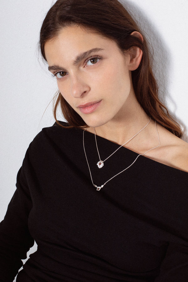 Silver textured round pendant necklace with red gemstone on model portrait
