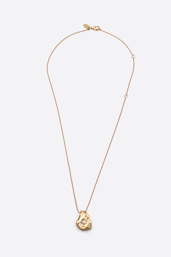 Gold textured organic pendant necklace with clear gemstone flat lay