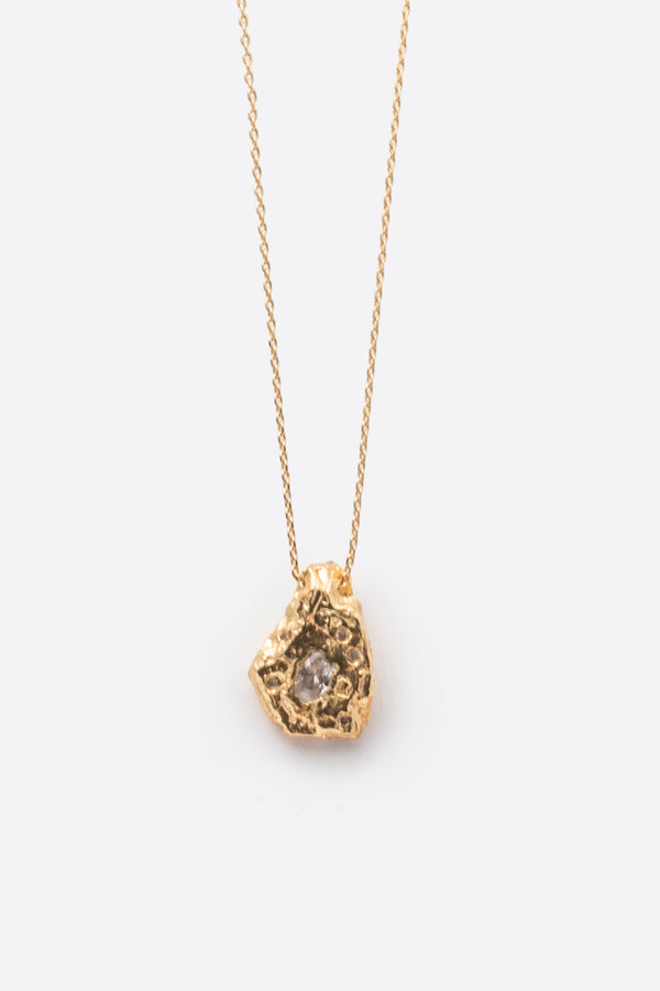 Gold textured organic pendant necklace with clear gemstone close-up