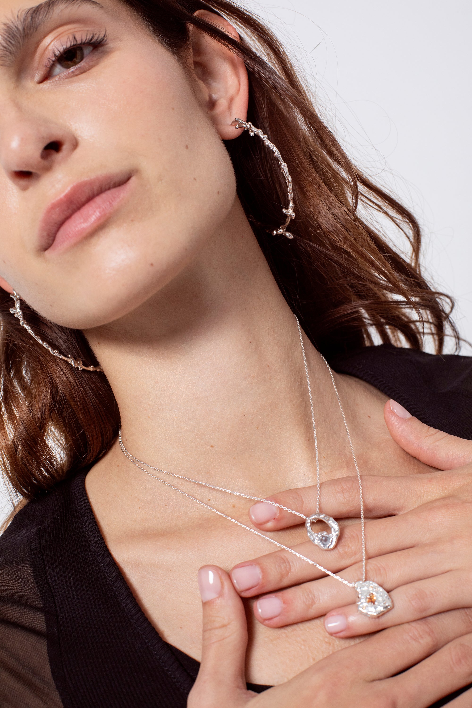 Layered silver textured pendant necklaces worn on model