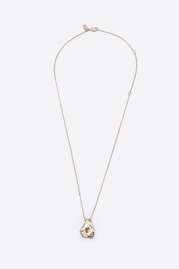 Silver textured organic pendant necklace with clear gemstone flat lay