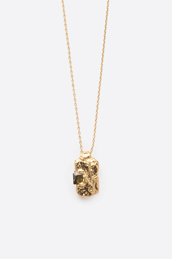 Close-up of gold textured rectangular pendant with square dark gemstone
