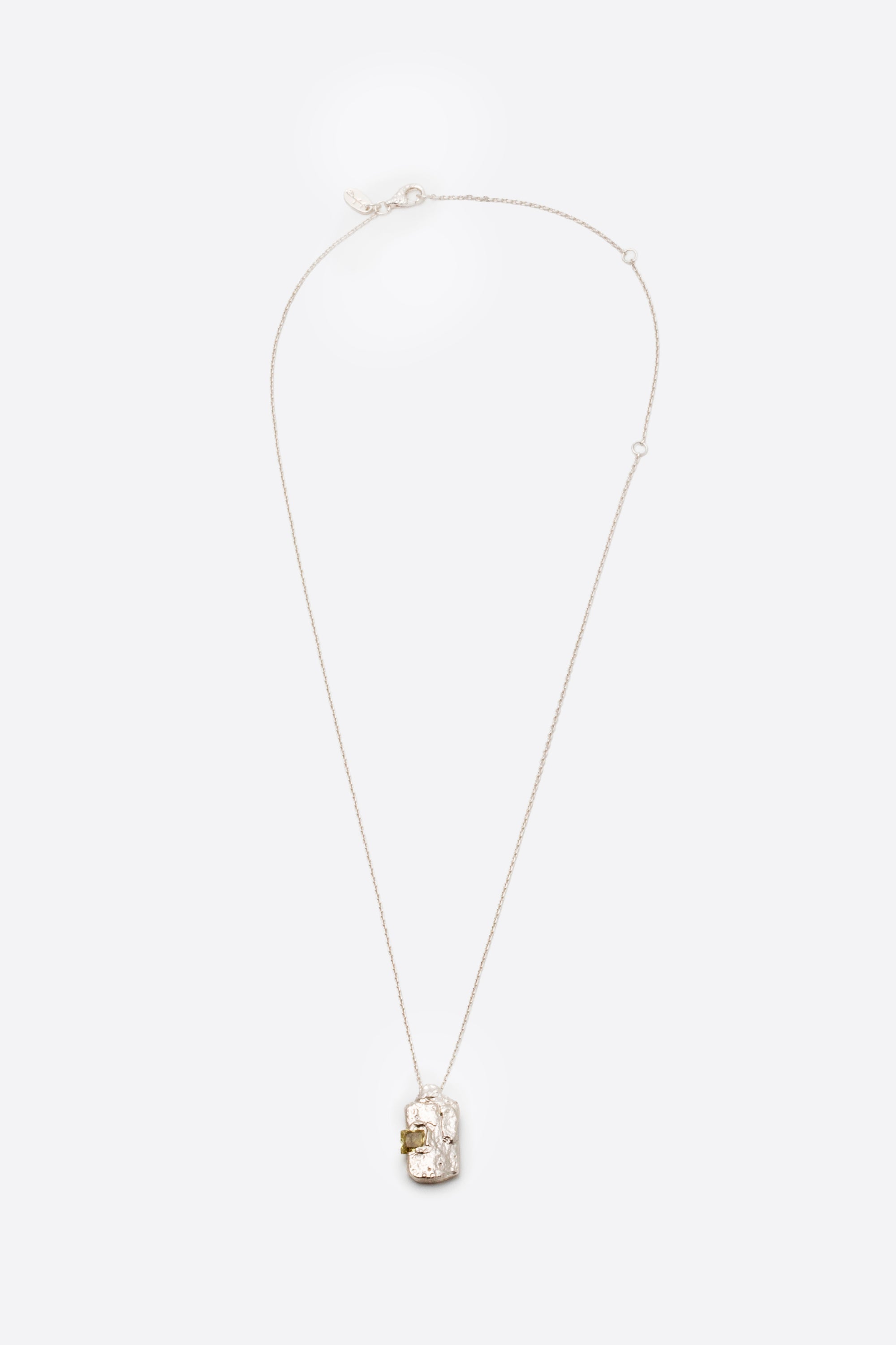 Silver textured rectangular pendant necklace with square yellow gemstone flat lay