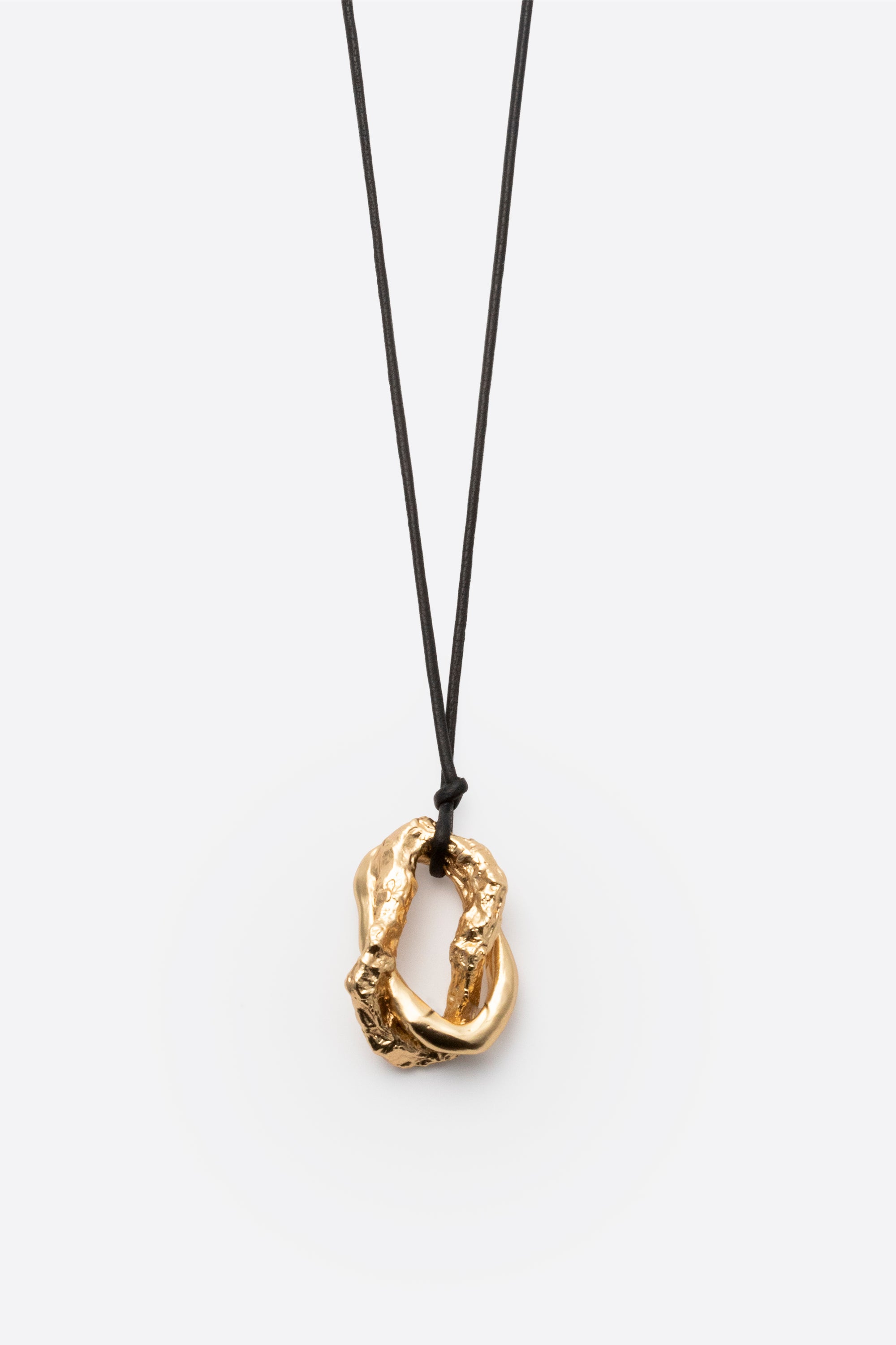 Textured gold pendant on black cord necklace