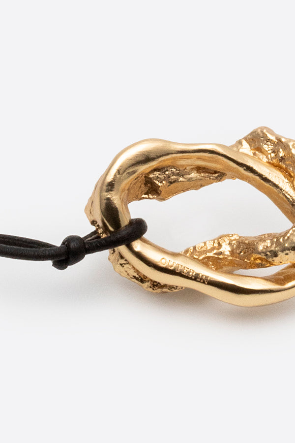 Close-up of organic gold pendant necklace detail