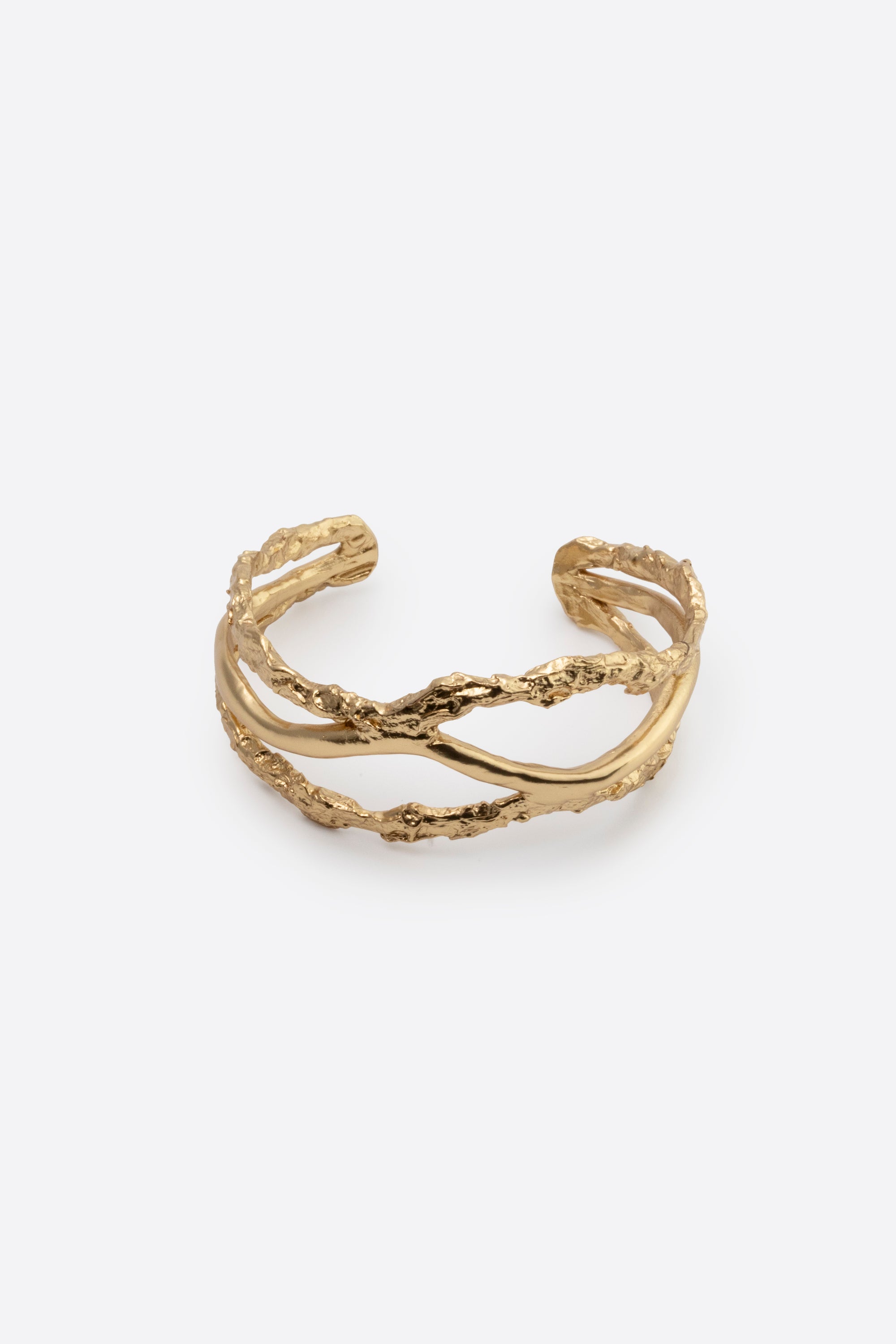 Sculptural gold cuff bracelet with organic texture on white background