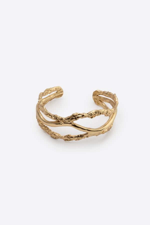 Sculptural gold cuff bracelet with organic texture on white background
