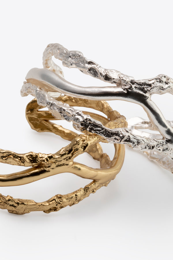 Gold and silver sculptural cuff bracelets with textured organic finish