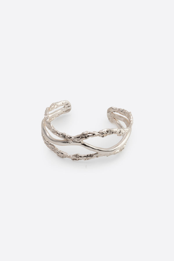 Sculptural silver cuff bracelet with organic texture on white background