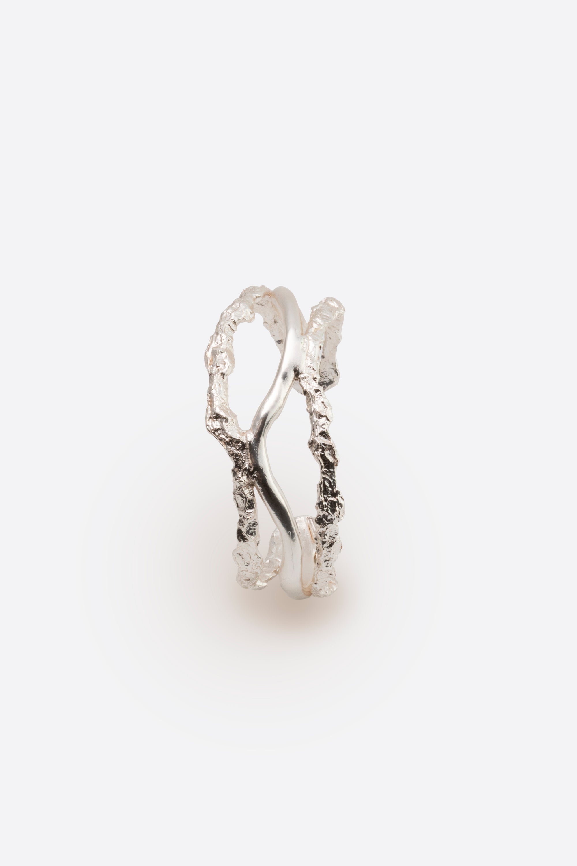 Side view of sculptural silver cuff bracelet with intertwined organic design