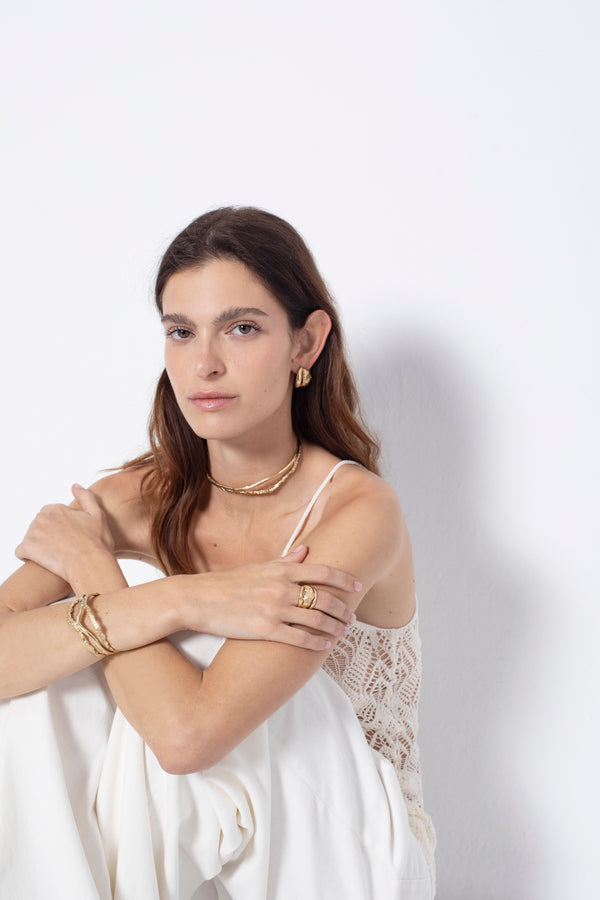 Model styling sculptural gold cuff bracelet as a statement accessory