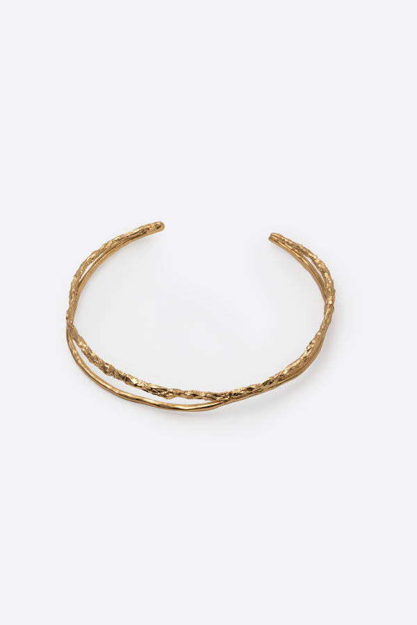 Sculptural gold choker necklace with organic texture on white background